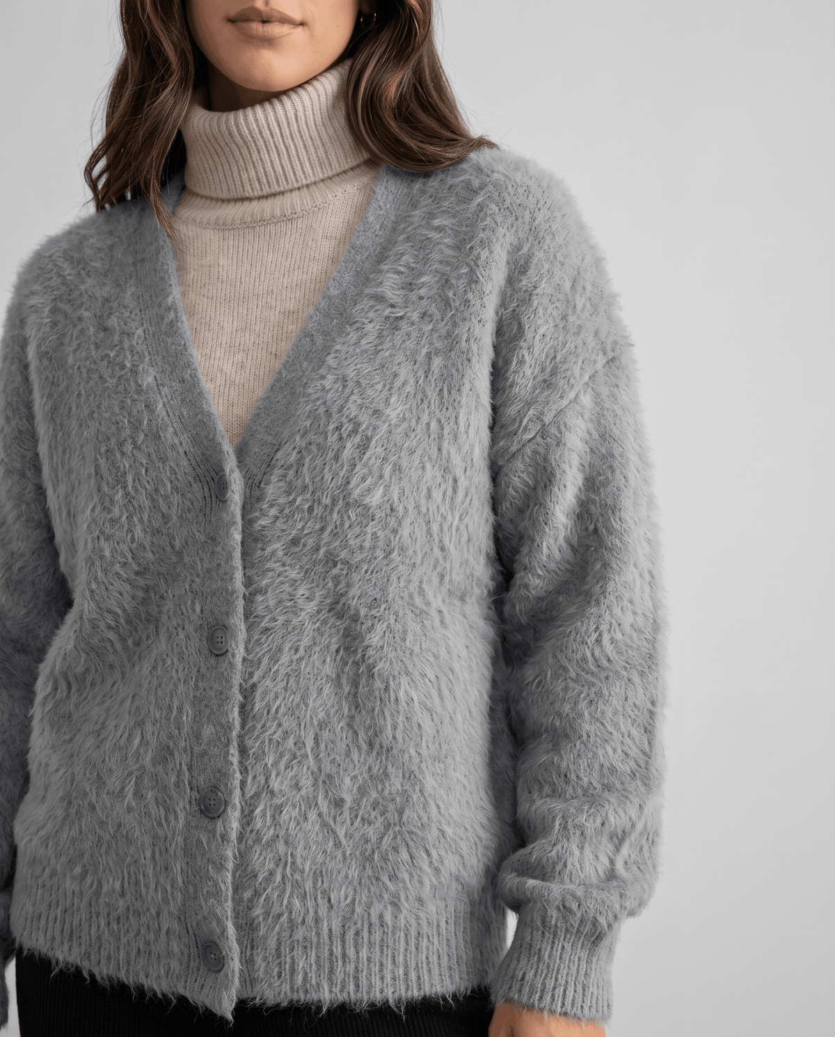 Close-up of the light gray textured knit buttoned over a taupe turtleneck