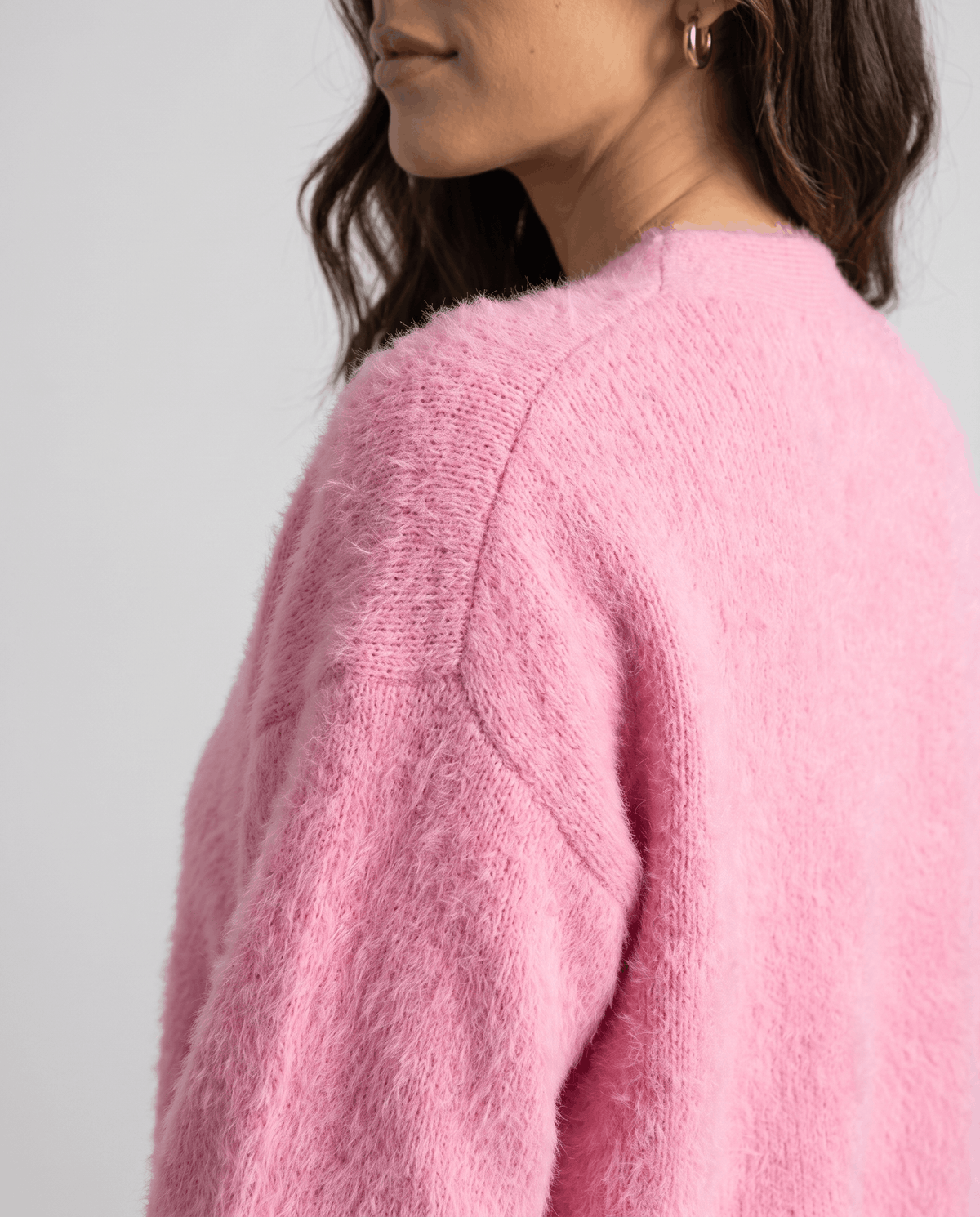 Detail of the pink fuzzy knit along the raglan shoulder seam