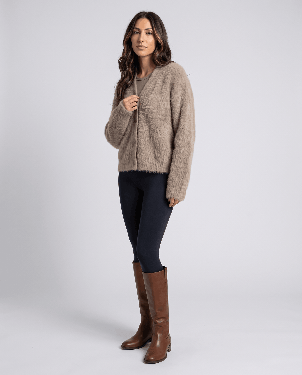 Taupe cardigan with black leggings and brown knee-high boots