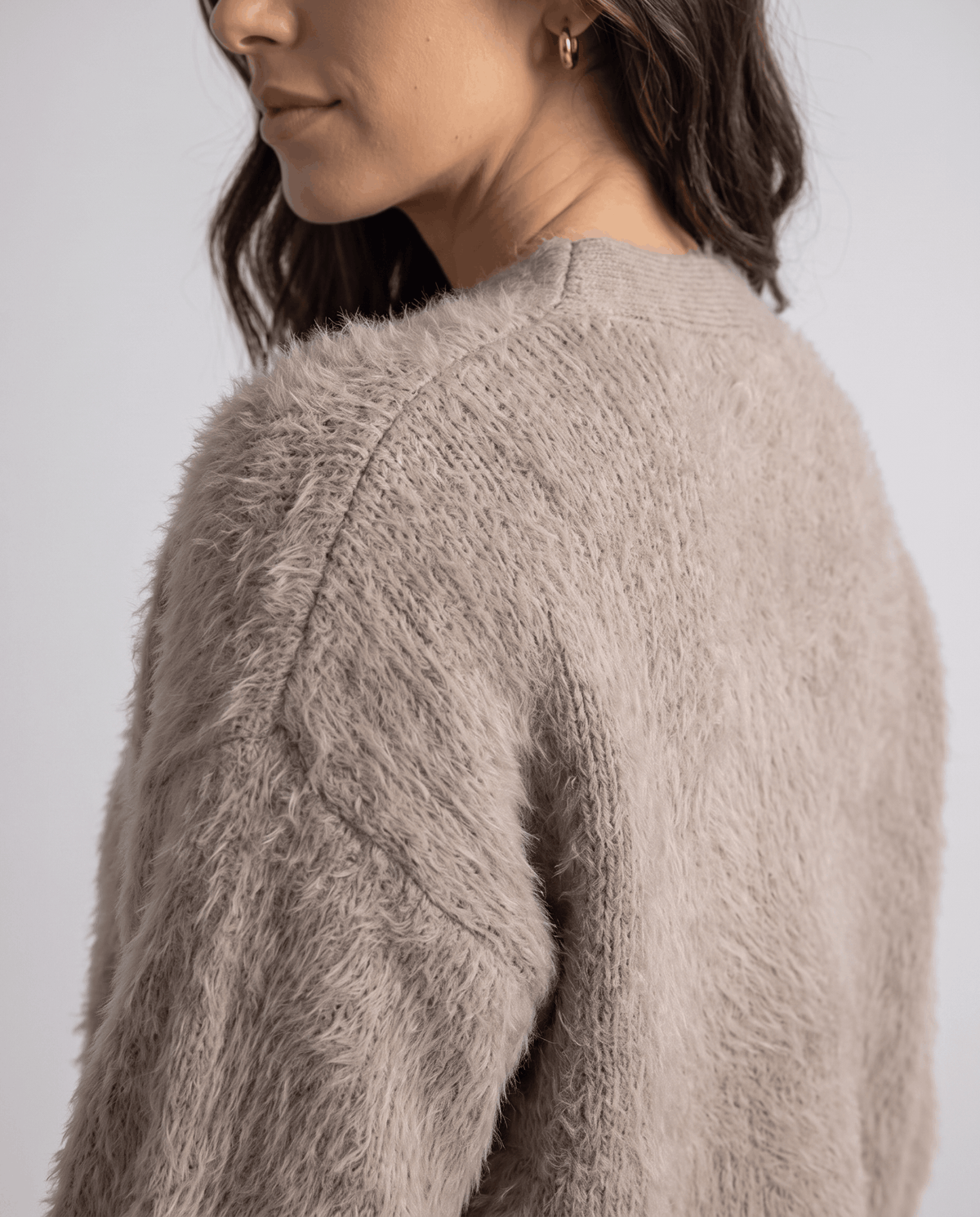 Detail of the taupe fuzzy knit along the raglan shoulder seam