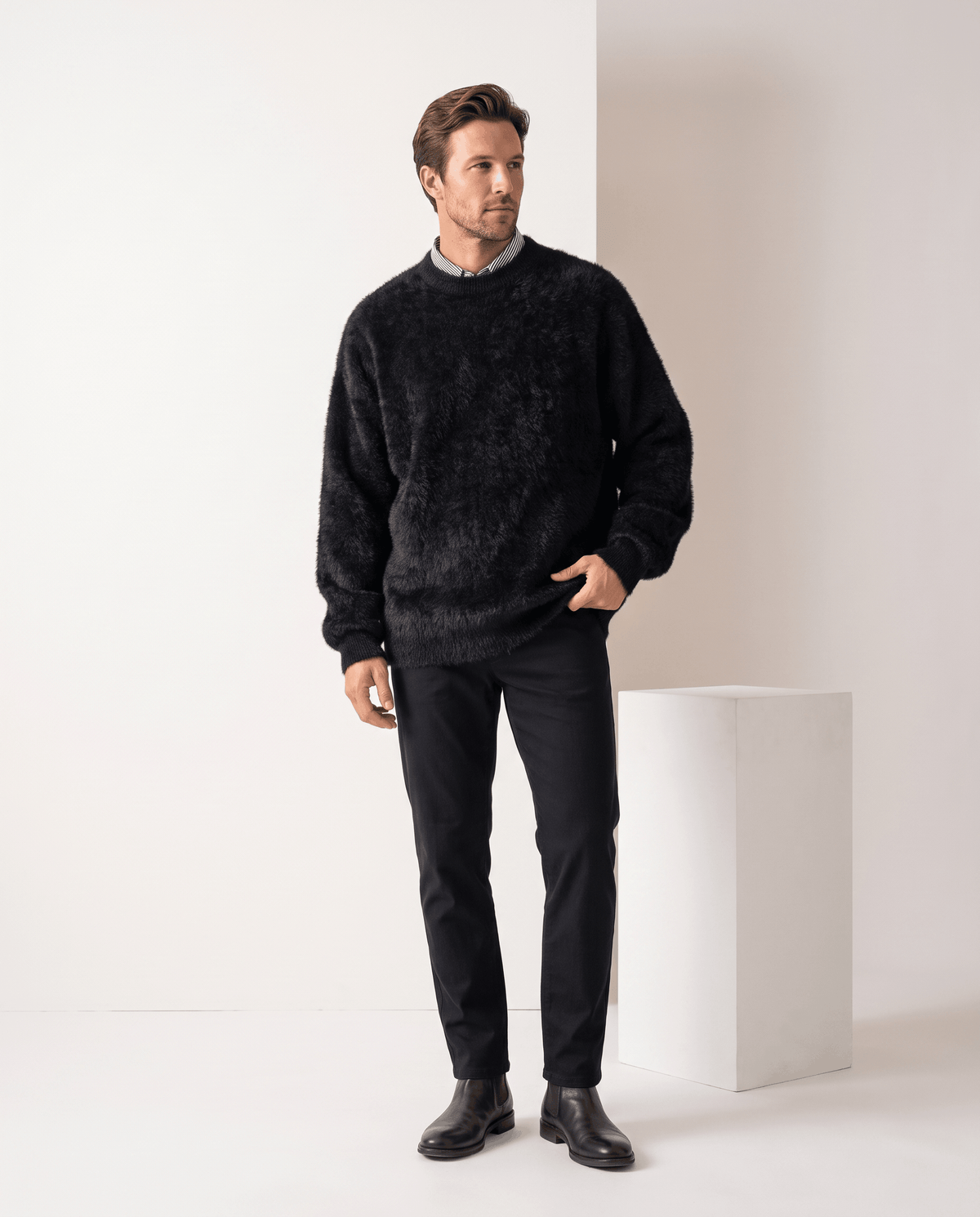 Full-length view of the black pullover with black jeans and dark leather boots
