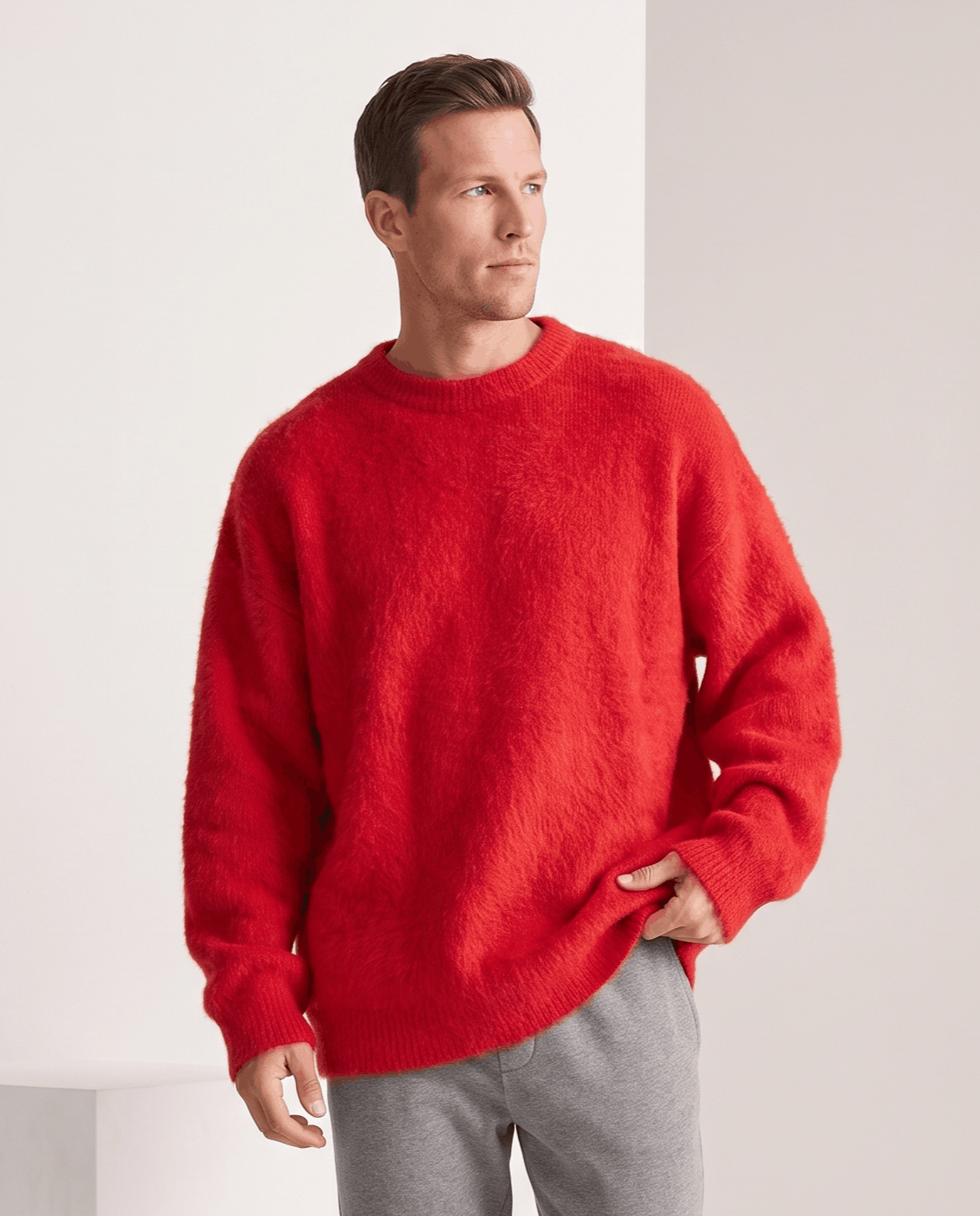 Red oversized pullover with gray trousers and a hand in pocket
