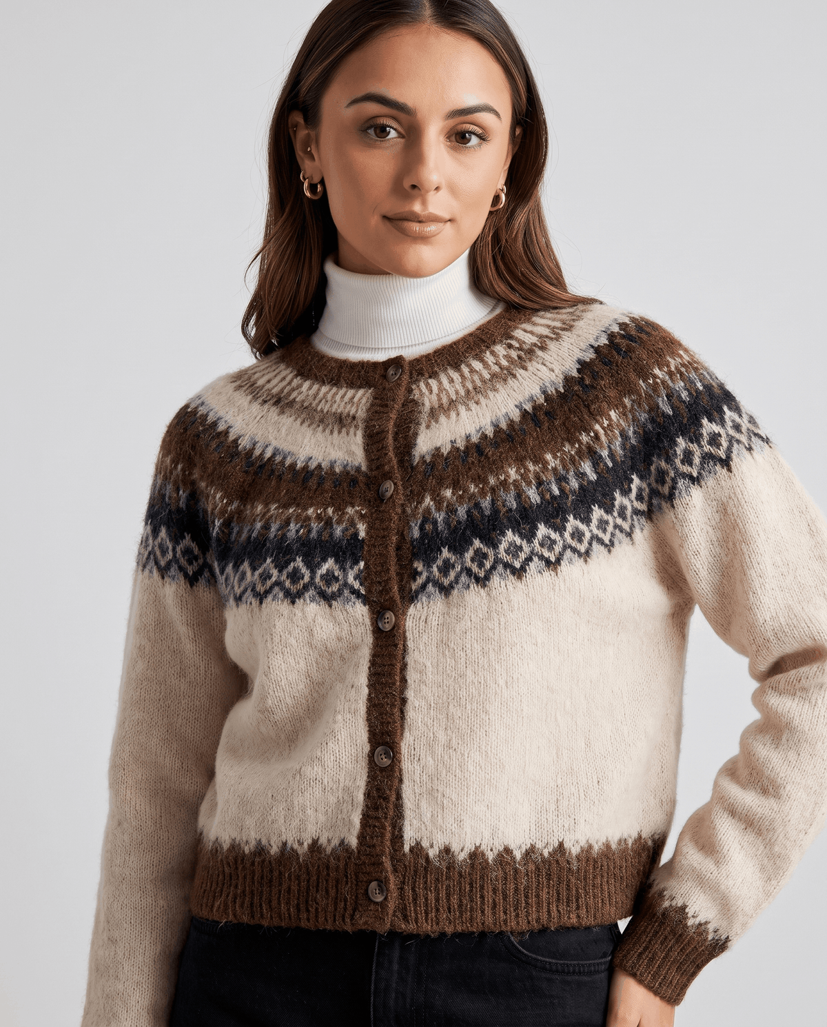 Close-up of the beige cardigan buttoned over a white turtleneck
