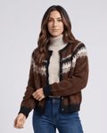 Women's fuzzy Fair Isle cardigan in brown over a cream turtleneck with jeans