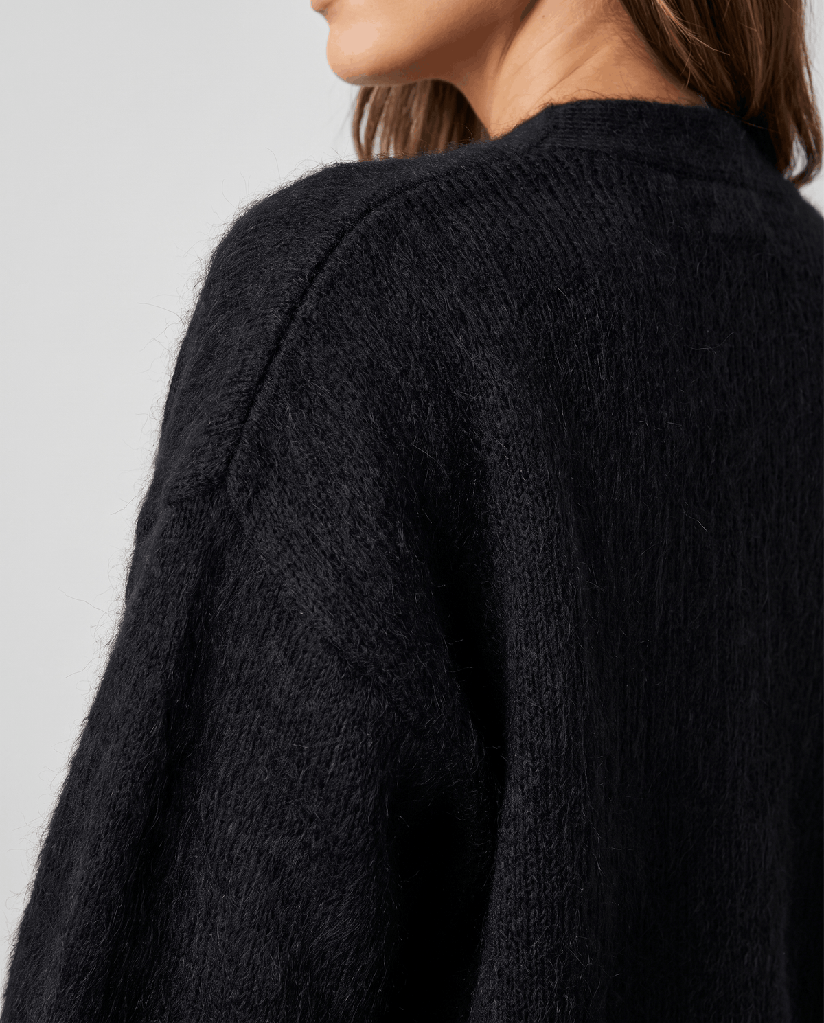 Detail of the black brushed knit along the raglan shoulder seam