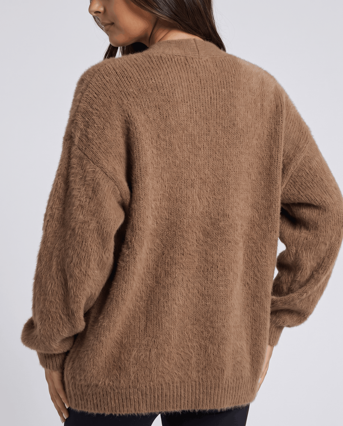 Back view of the brown cardigan showing its relaxed shape and ribbed hem