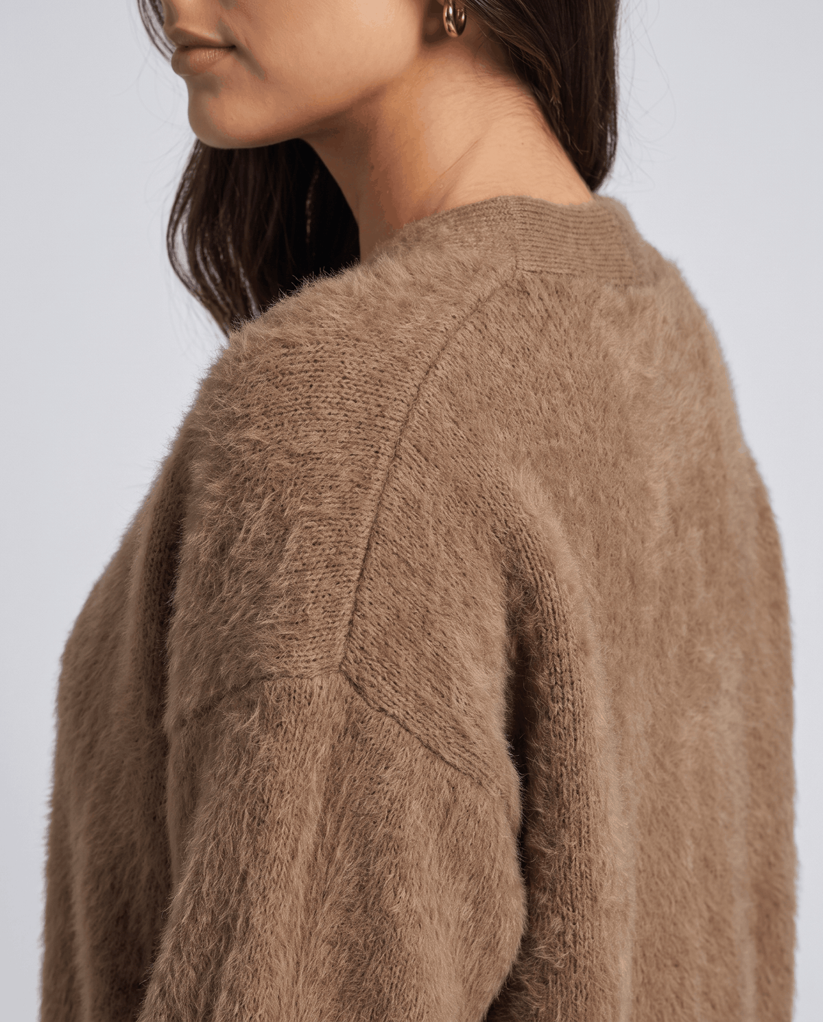 Detail of the brown fuzzy knit along the raglan seam at the shoulder