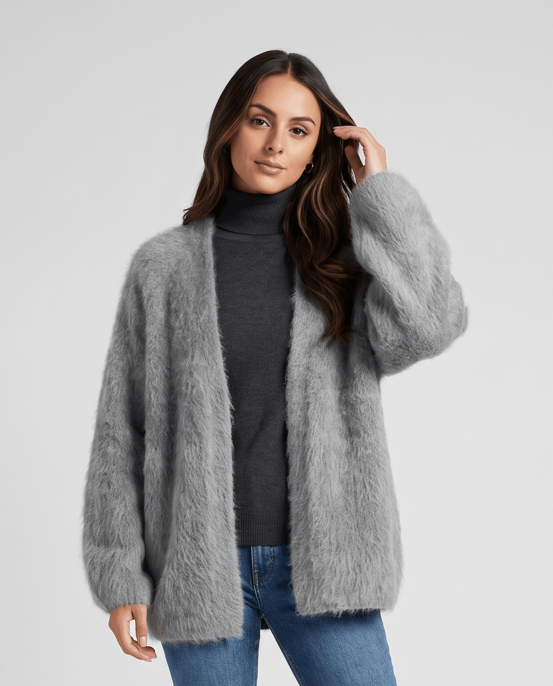 Gray cardigan worn open over a dark turtleneck and blue jeans