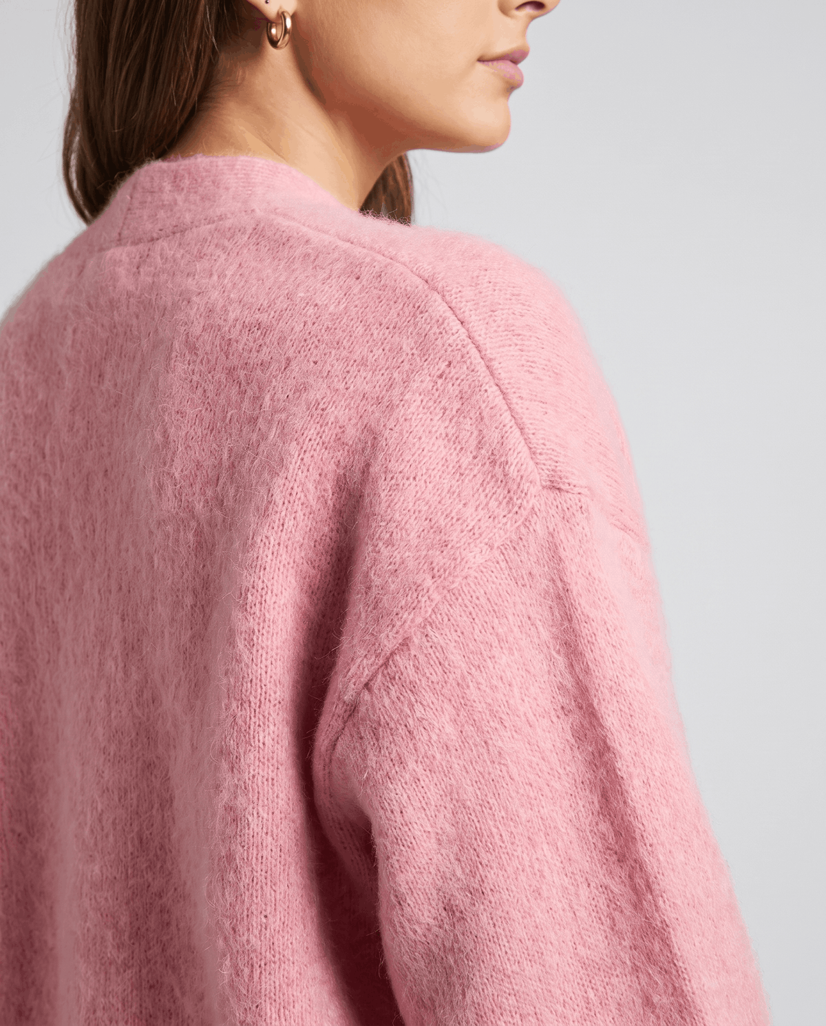 Close-up of the pink brushed knit along the raglan shoulder seam and sleeve