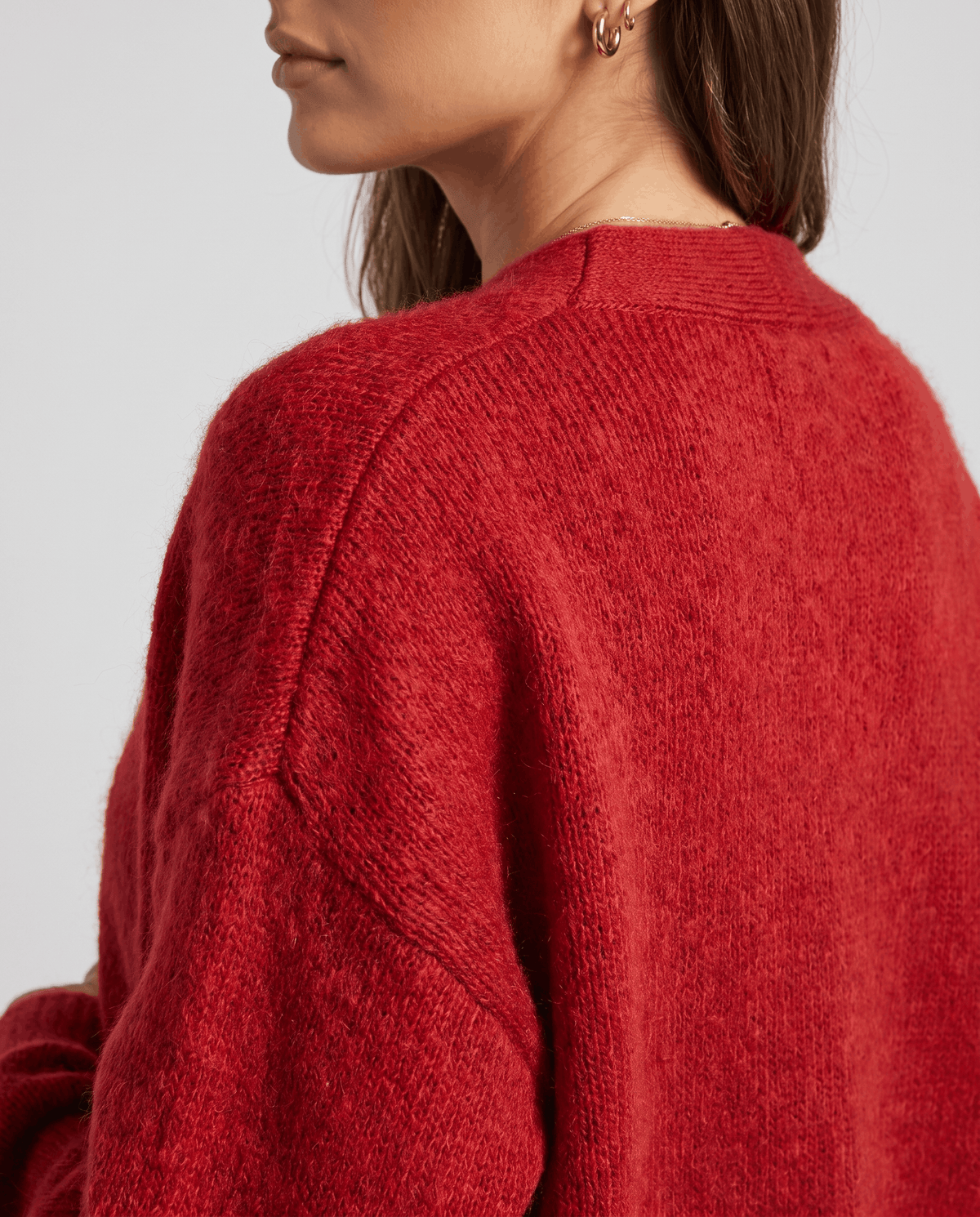 Back detail of the red fuzzy knit along the raglan shoulder seam