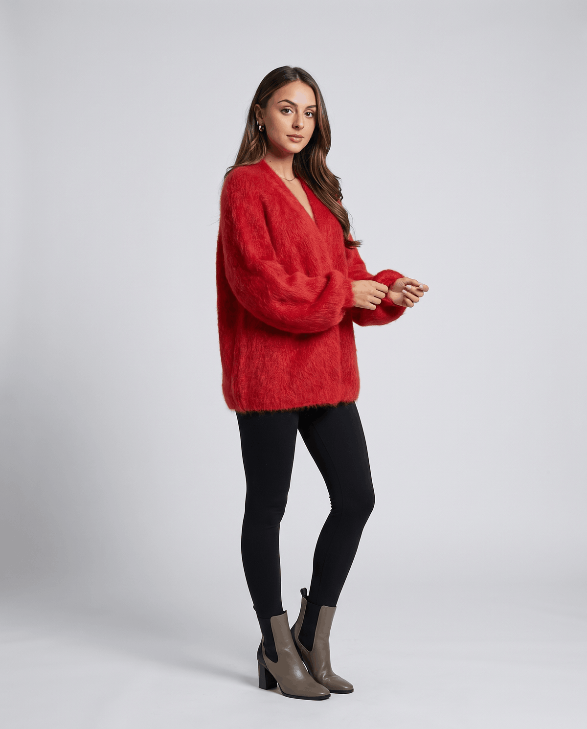 Full-length red cardigan styled with black leggings and gray ankle boots