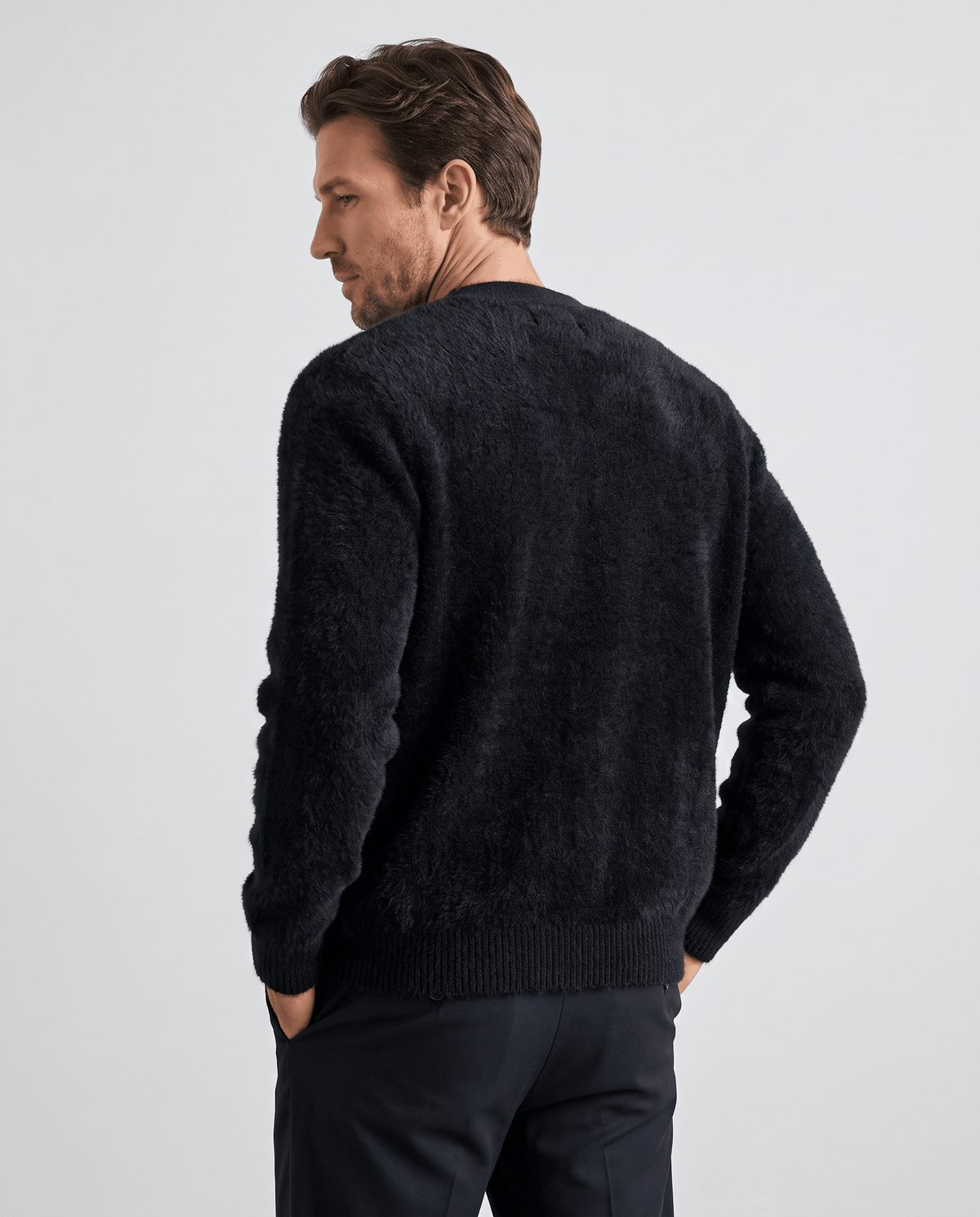 Back view of the black fuzzy cardigan showing dropped shoulders and a ribbed hem