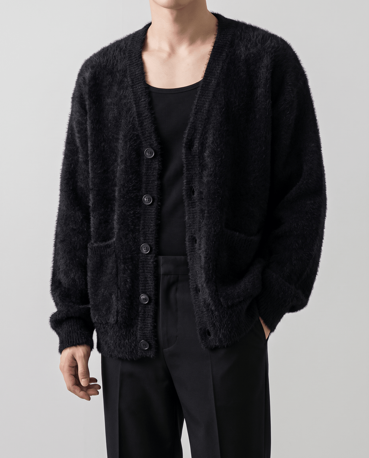 Front close-up of the black brushed knit cardigan worn open over a black tank