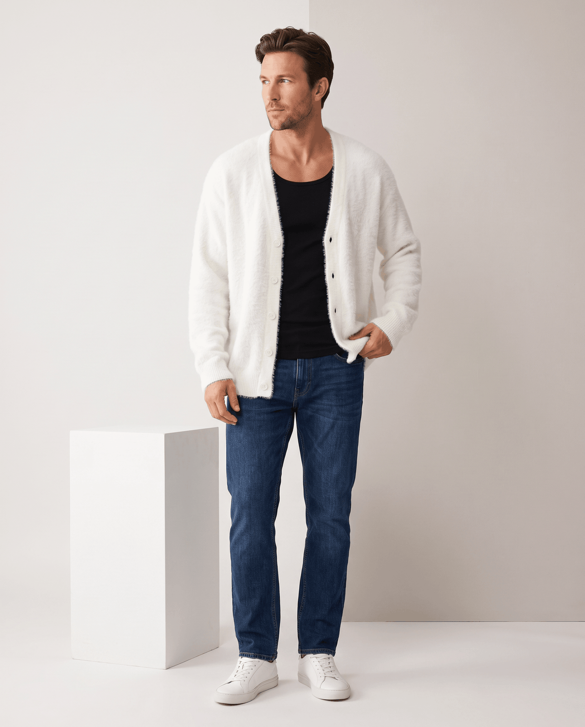 Full-length view of the white cardigan over a black tank with jeans and sneakers