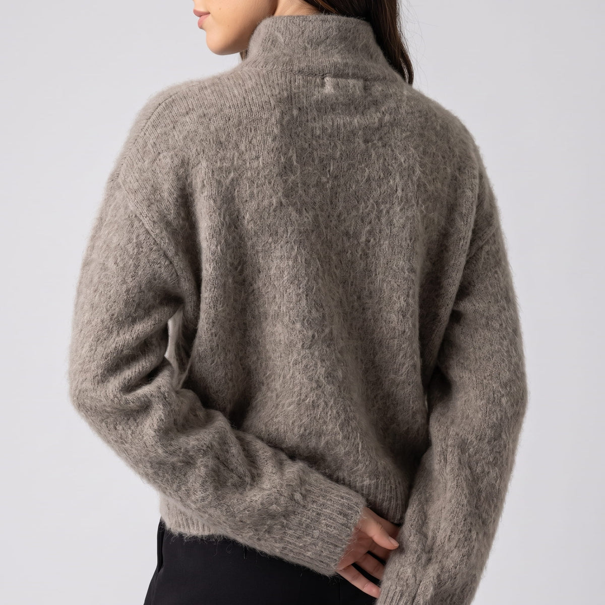 Back view of the boxy taupe knit cardigan showing dropped shoulders and ribbed cuffs