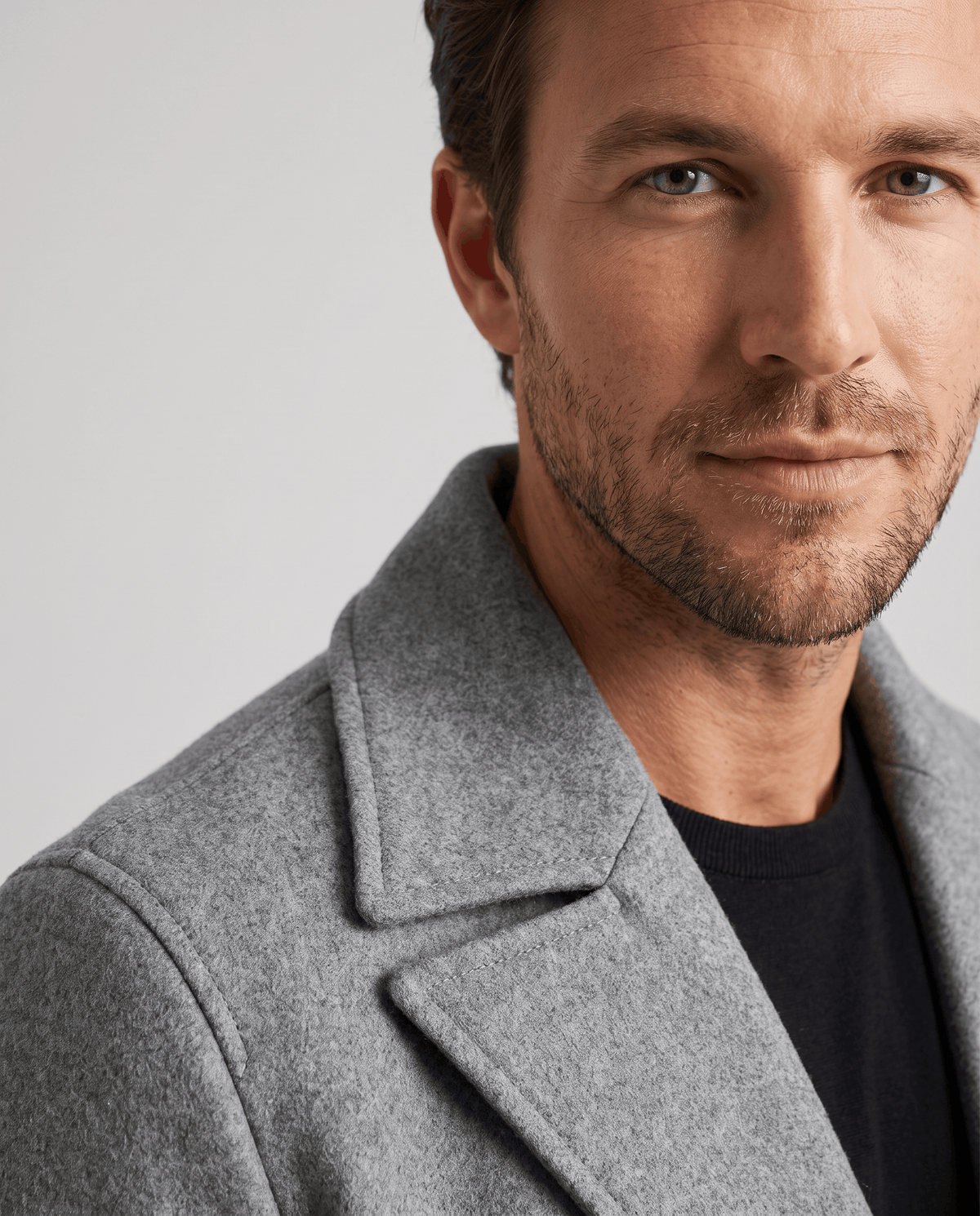 Close-up of the wide notch lapel on a textured gray wool coat