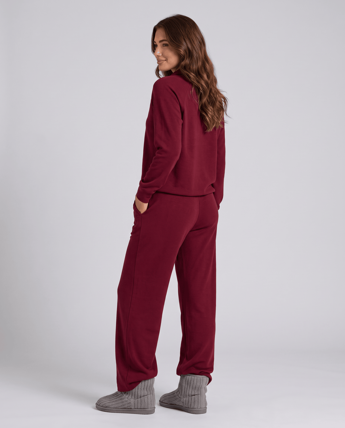 Back view of burgundy long-sleeve top and wide-leg pants with gray socks