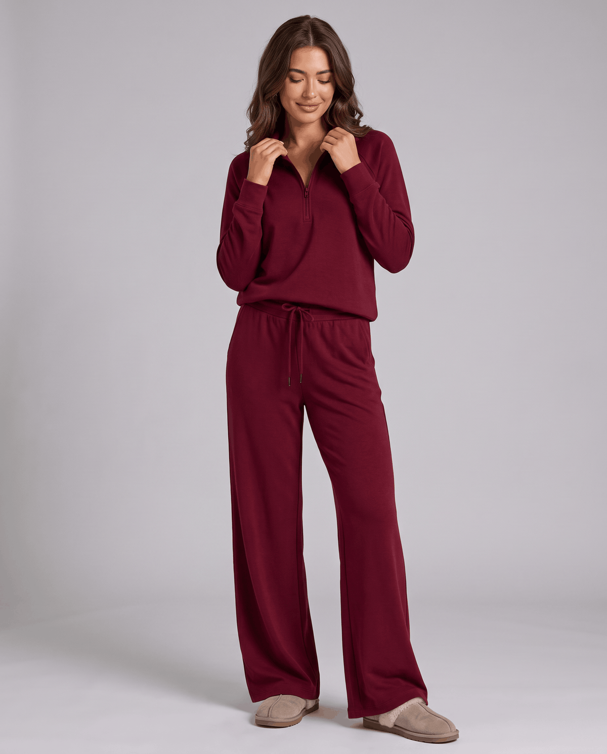 Woman in burgundy half-zip top and wide-leg pants with a drawstring waist, full-length view