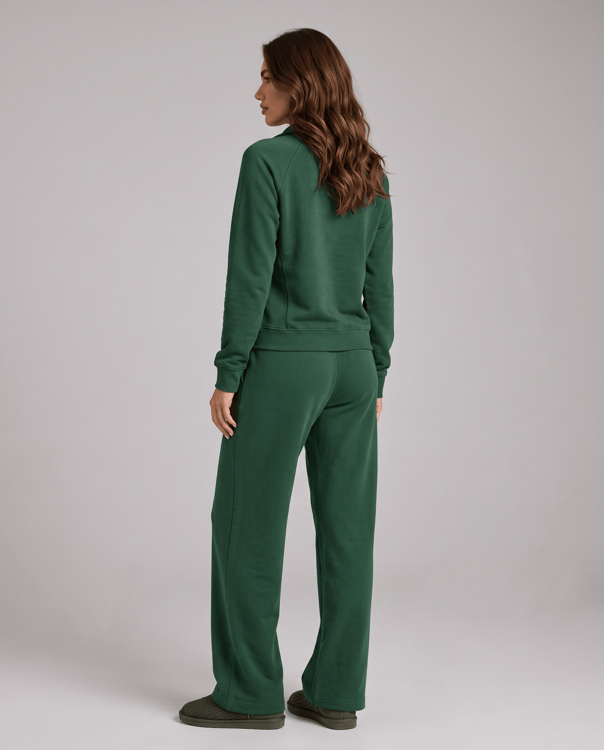 Back view of green long-sleeve top and wide-leg pants on a standing model