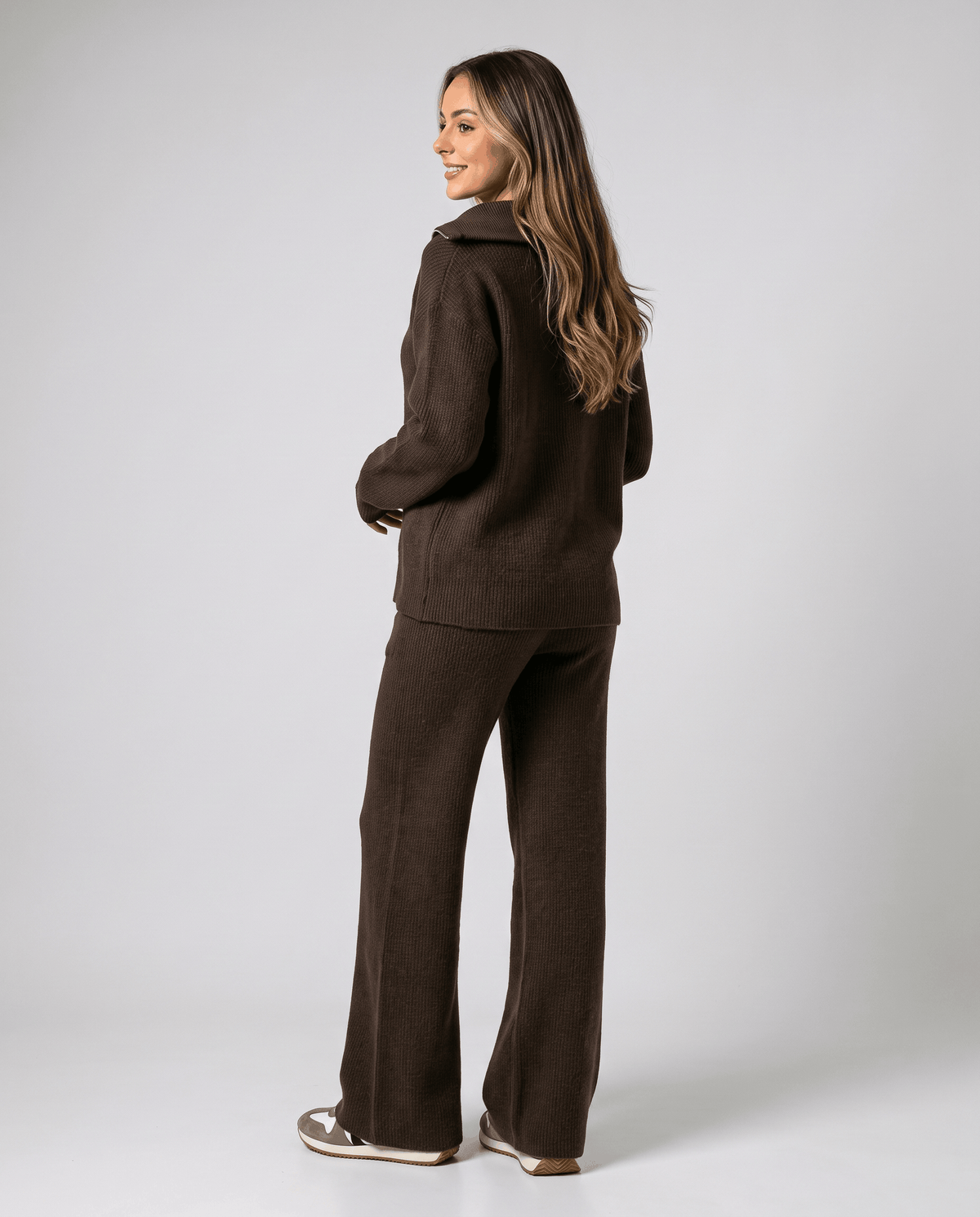 Back view of the dark brown knit pullover and wide-leg pants, full-length