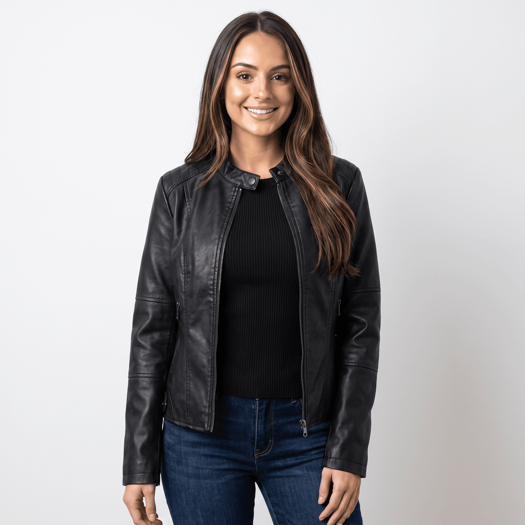 Woman wearing a black faux leather jacket with a round neckline, zip-front closure, and fitted silhouette over a black knit top and blue jeans.