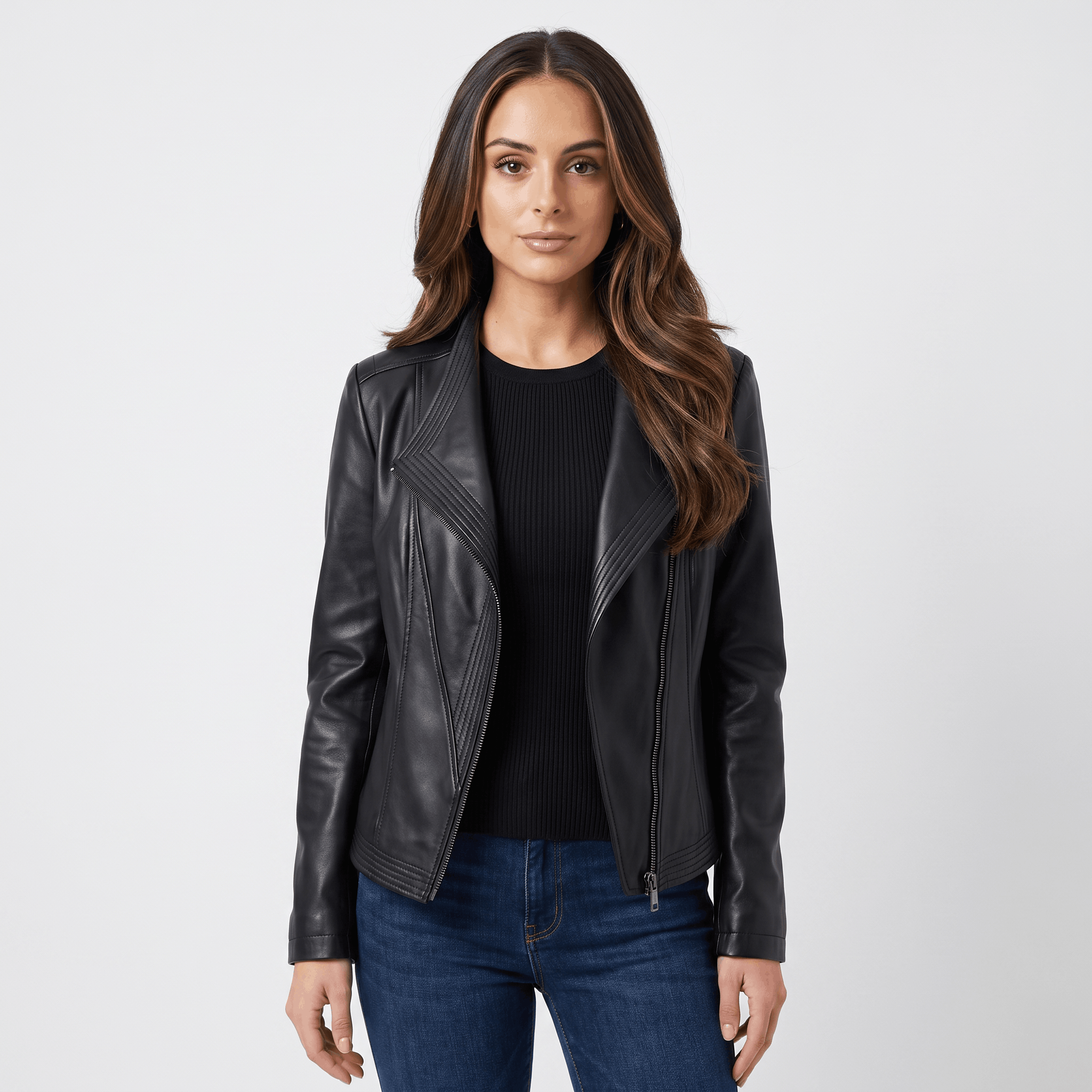 Woman wearing a black leather moto jacket with an asymmetrical zip closure, notched lapel, and fitted silhouette over a black top.