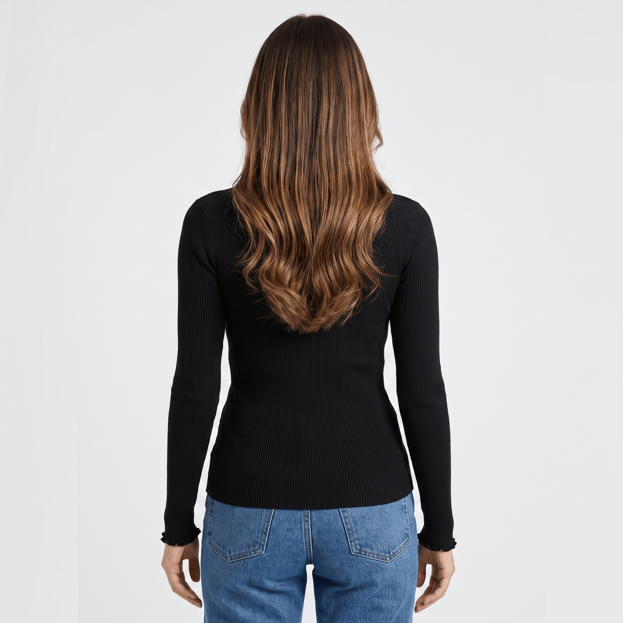 Back view of a woman wearing a black ribbed long sleeve top with a fitted silhouette and textured knit fabric.