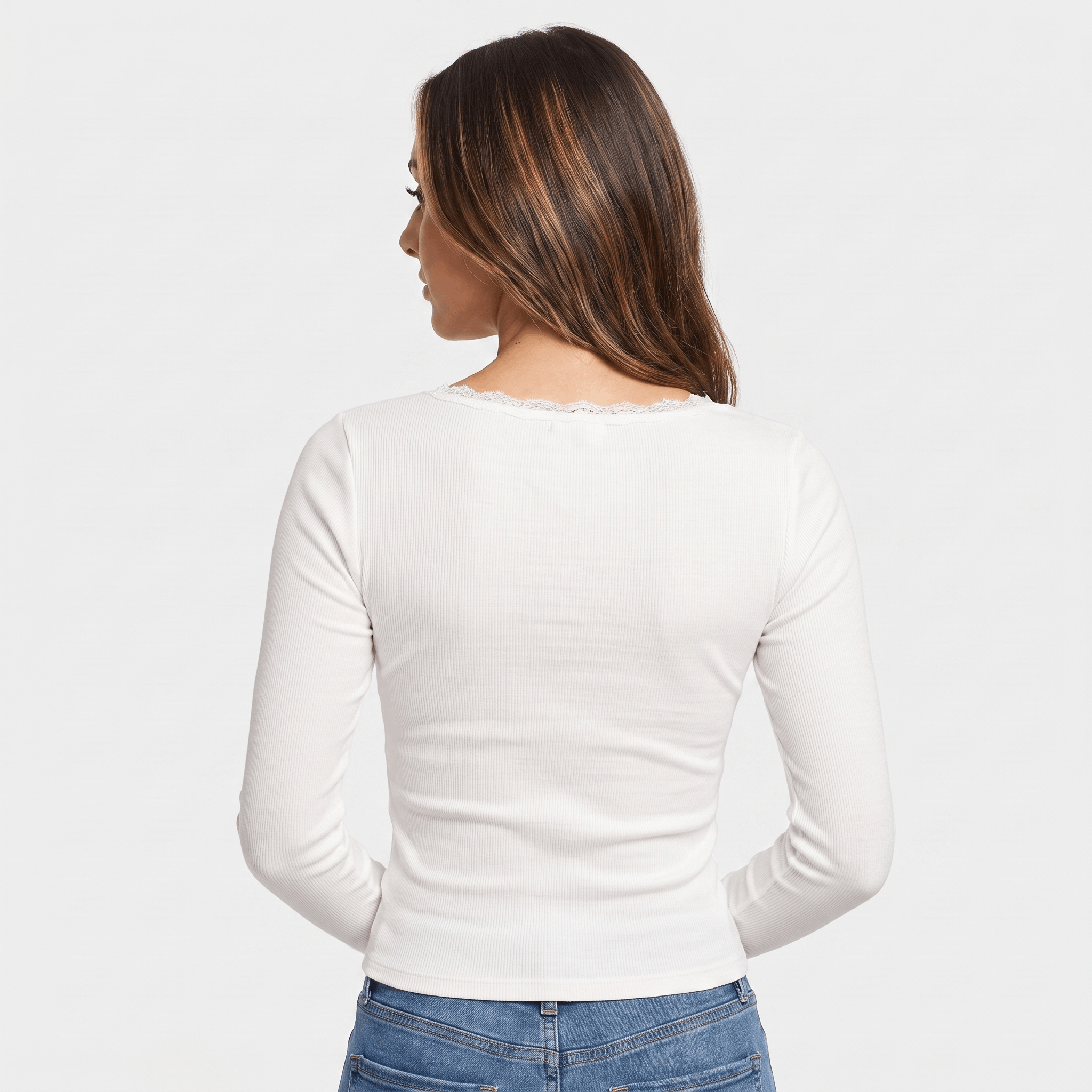 Back view of a woman wearing a white fitted long sleeve top with a smooth ribbed texture and minimalist design.