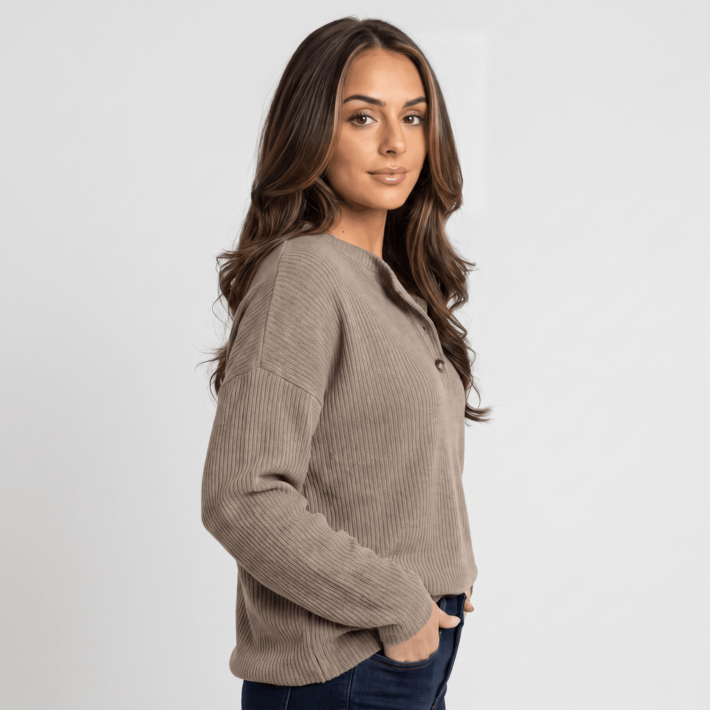 Side view of a woman wearing a taupe ribbed henley sweater with a button neckline and long sleeves.