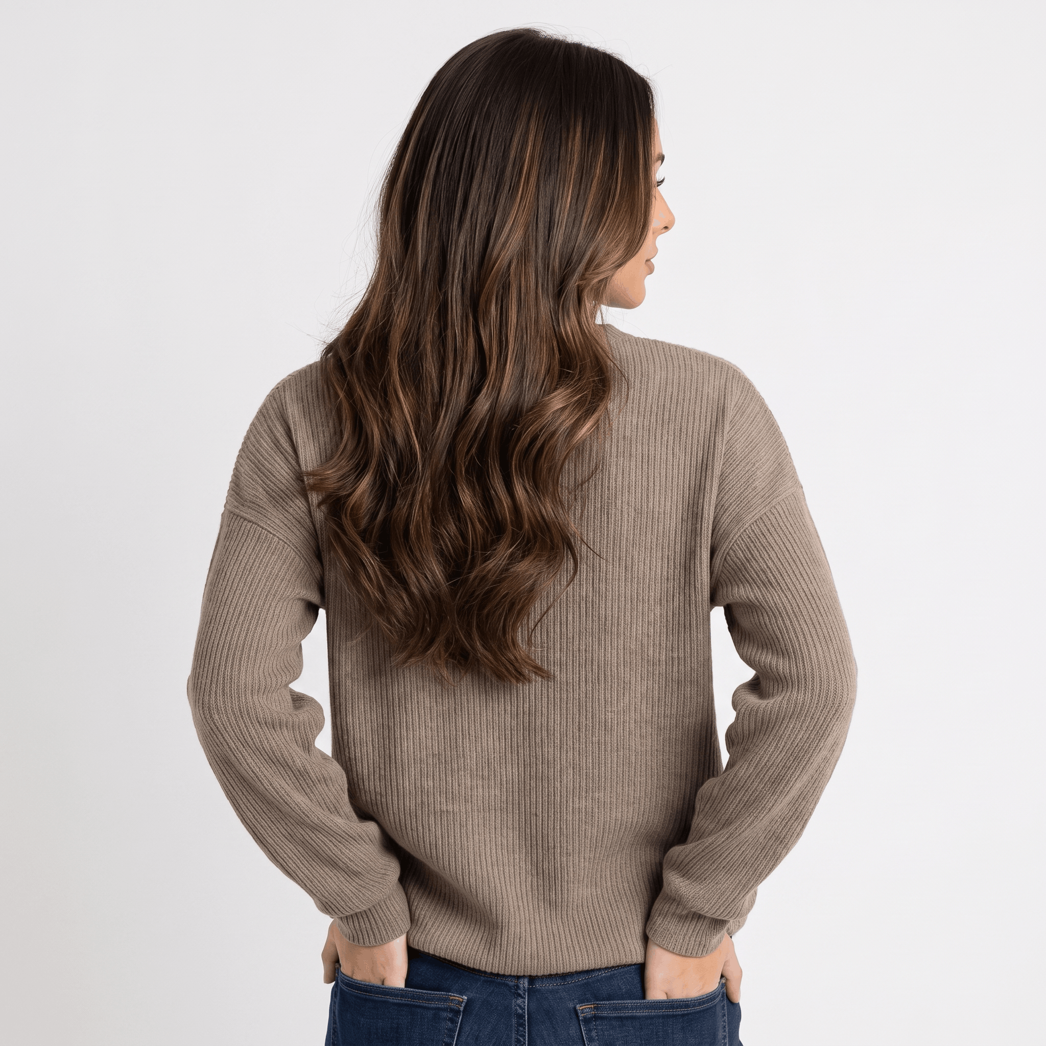 Back view of a woman wearing a taupe ribbed henley sweater with a textured knit finish and relaxed silhouette.