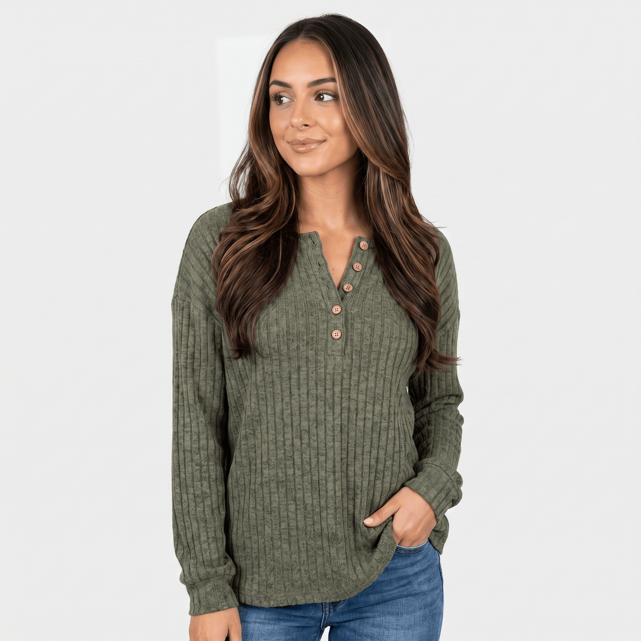Woman wearing an olive green textured henley sweater with a button neckline, long sleeves, and relaxed fit with blue jeans.