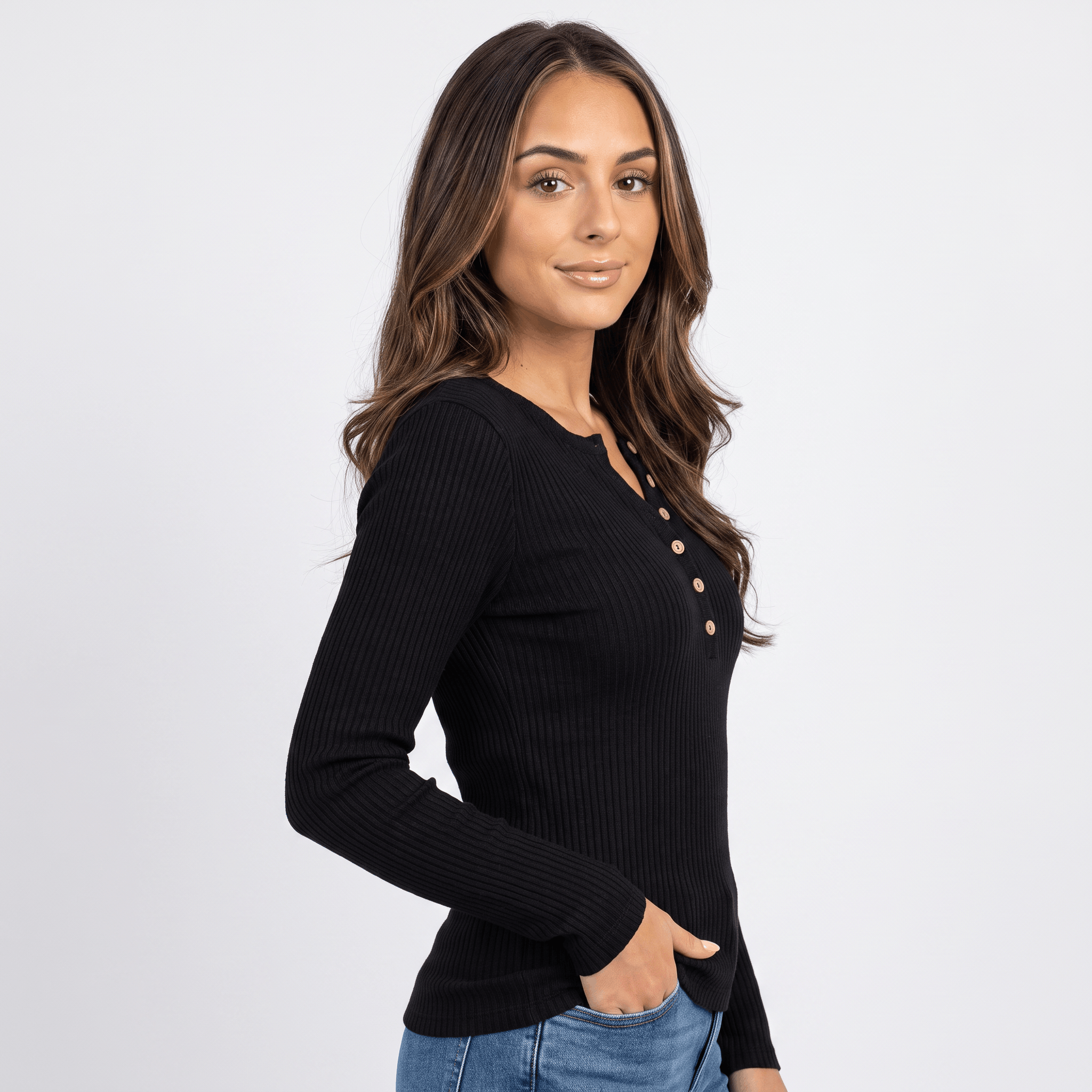 Woman wearing a black textured henley sweater with a button neckline and long sleeves.