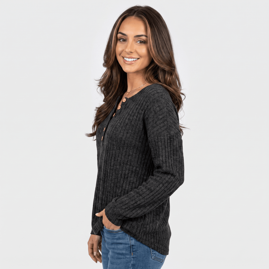 Side view of a woman wearing a black textured henley sweater with a button neckline and long sleeves.