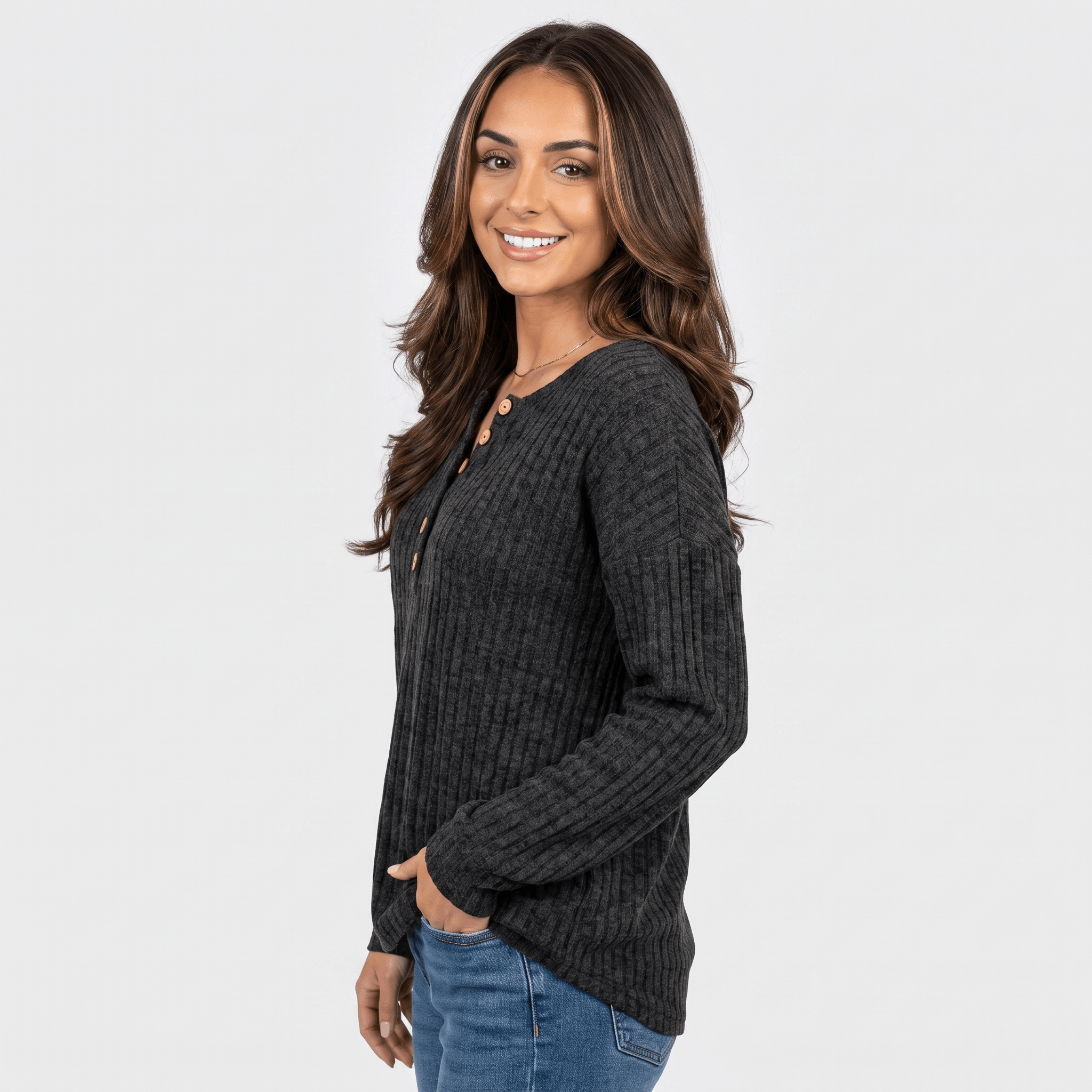 Side view of a woman wearing a black textured henley sweater with a button neckline and long sleeves.