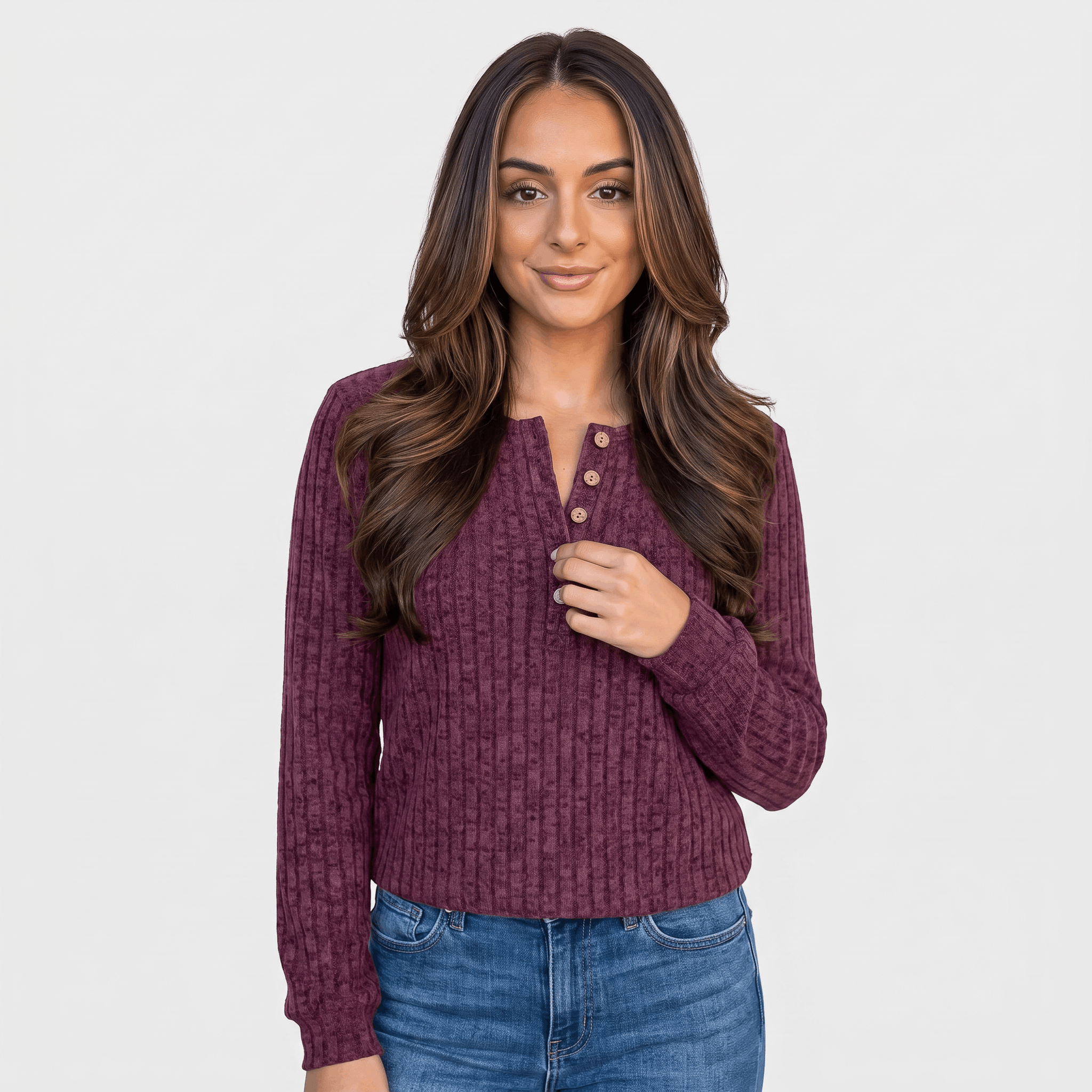 Woman wearing a burgundy textured henley sweater with a button neckline, long sleeves, and relaxed silhouette.