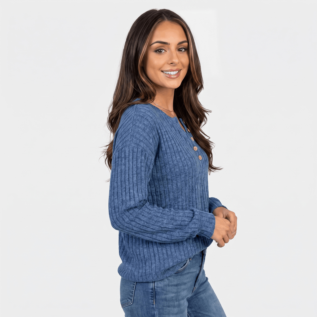 Side view of a woman wearing a blue textured henley sweater with a button neckline and long sleeves.