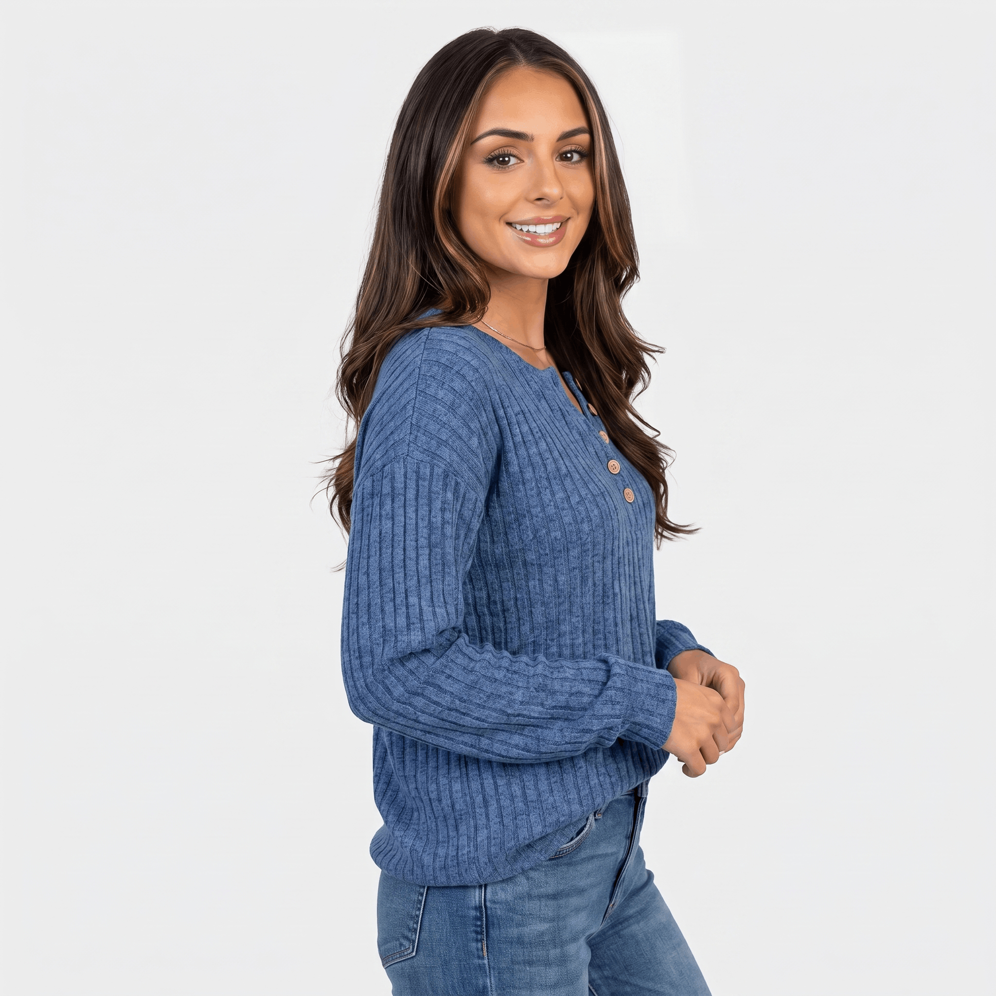 Side view of a woman wearing a blue textured henley sweater with a button neckline and long sleeves.