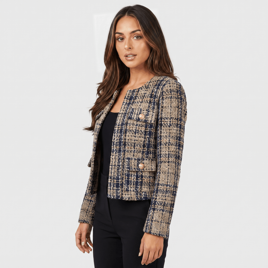 Side view of a woman wearing a blue and beige plaid tweed jacket with gold-tone buttons, long sleeves, and tailored silhouette.