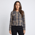 Woman wearing a blue and beige plaid tweed jacket with gold-tone buttons, round neckline, long sleeves, and tailored fit paired with black trousers.