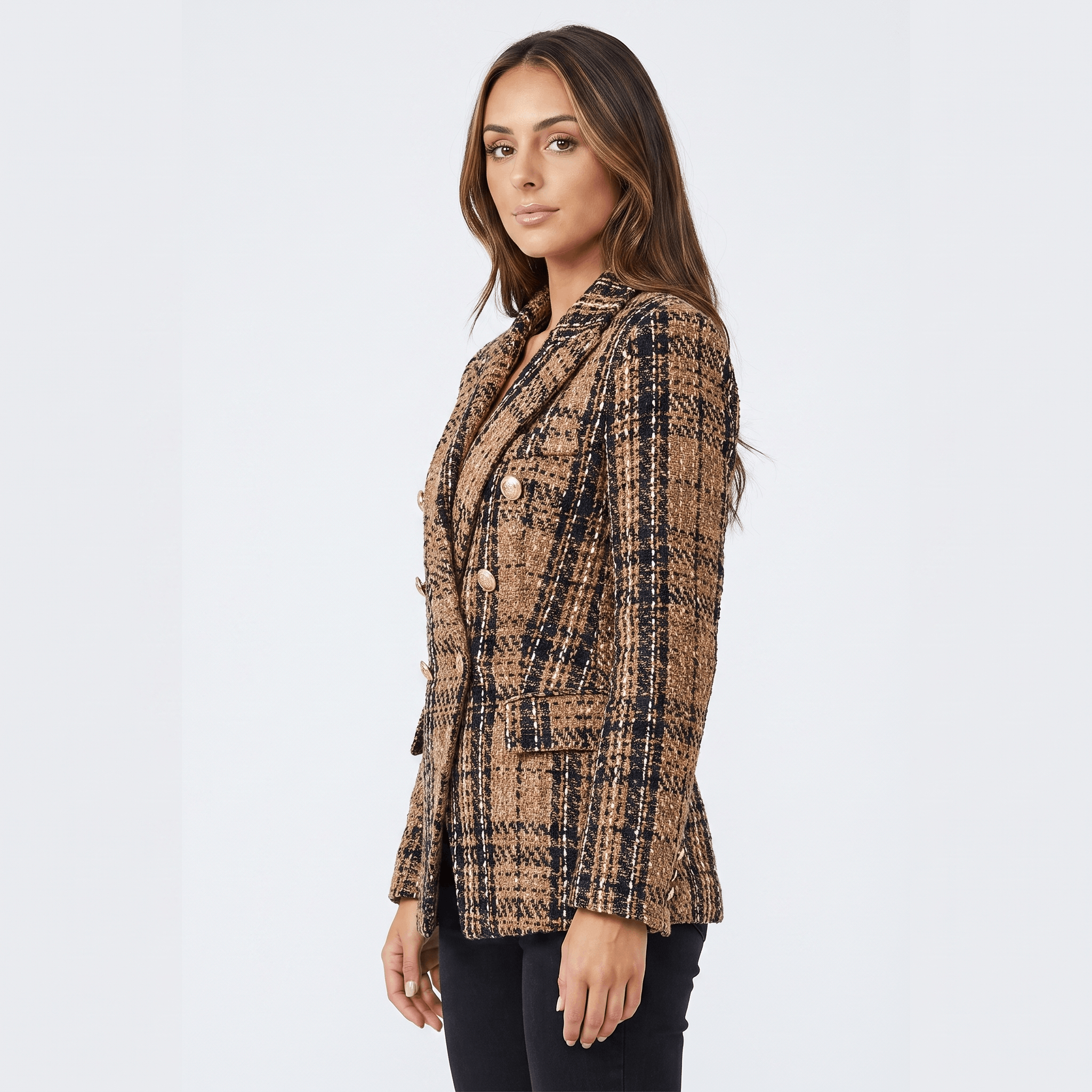 Side view of a woman wearing a brown plaid tweed blazer with a double-breasted front, notched lapels, and tailored silhouette.