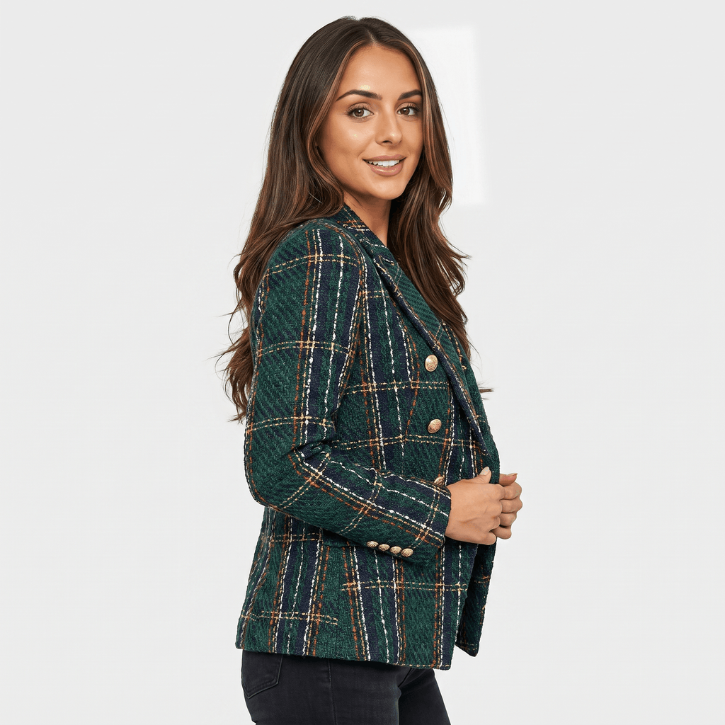 Side view of a woman wearing a dark green plaid tweed blazer with gold-tone buttons, notched lapels, and tailored silhouette.