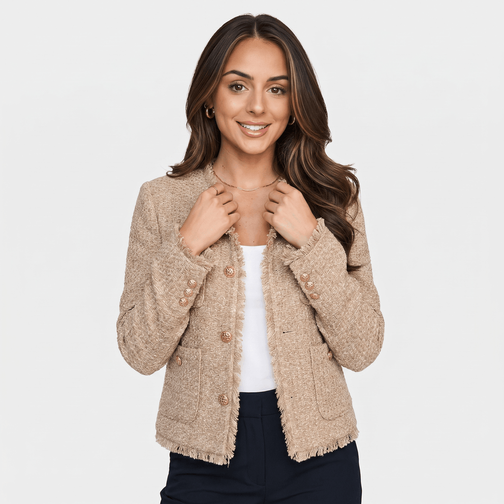 Front view of a woman wearing a beige textured tweed jacket with gold-tone buttons, round neckline, and cropped tailored fit.
