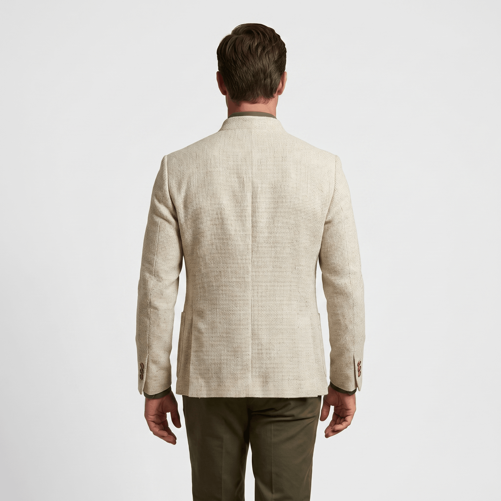 Back view of a man wearing a beige textured blazer with a tailored silhouette and long sleeves.