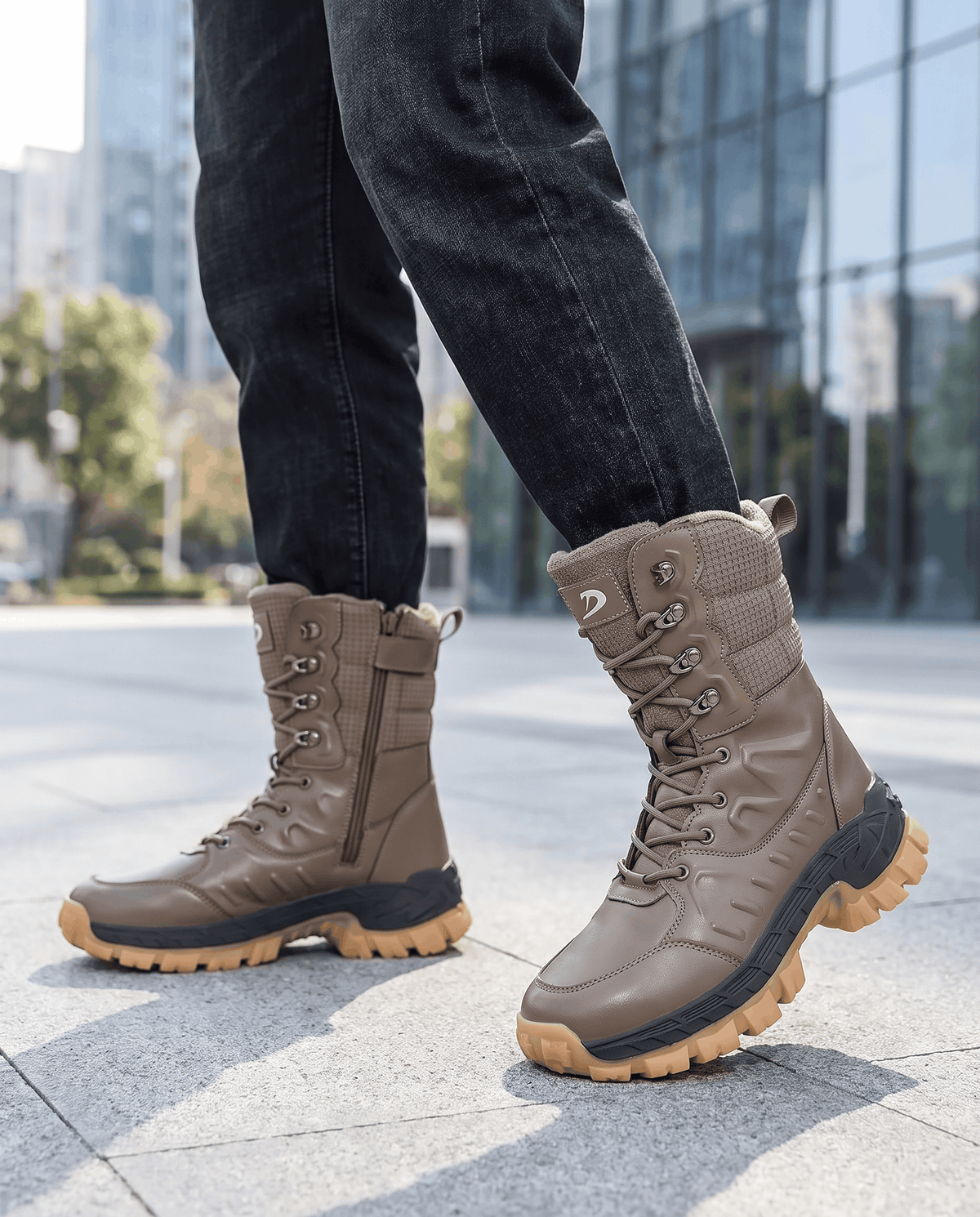 Man wearing khaki lace-up boots with dark jeans on a sunny city street