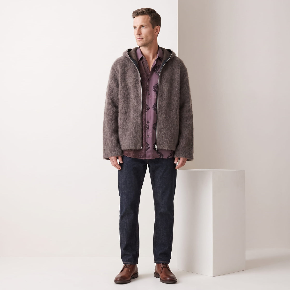 Full-length view of the brown cardigan over a plaid shirt with dark jeans