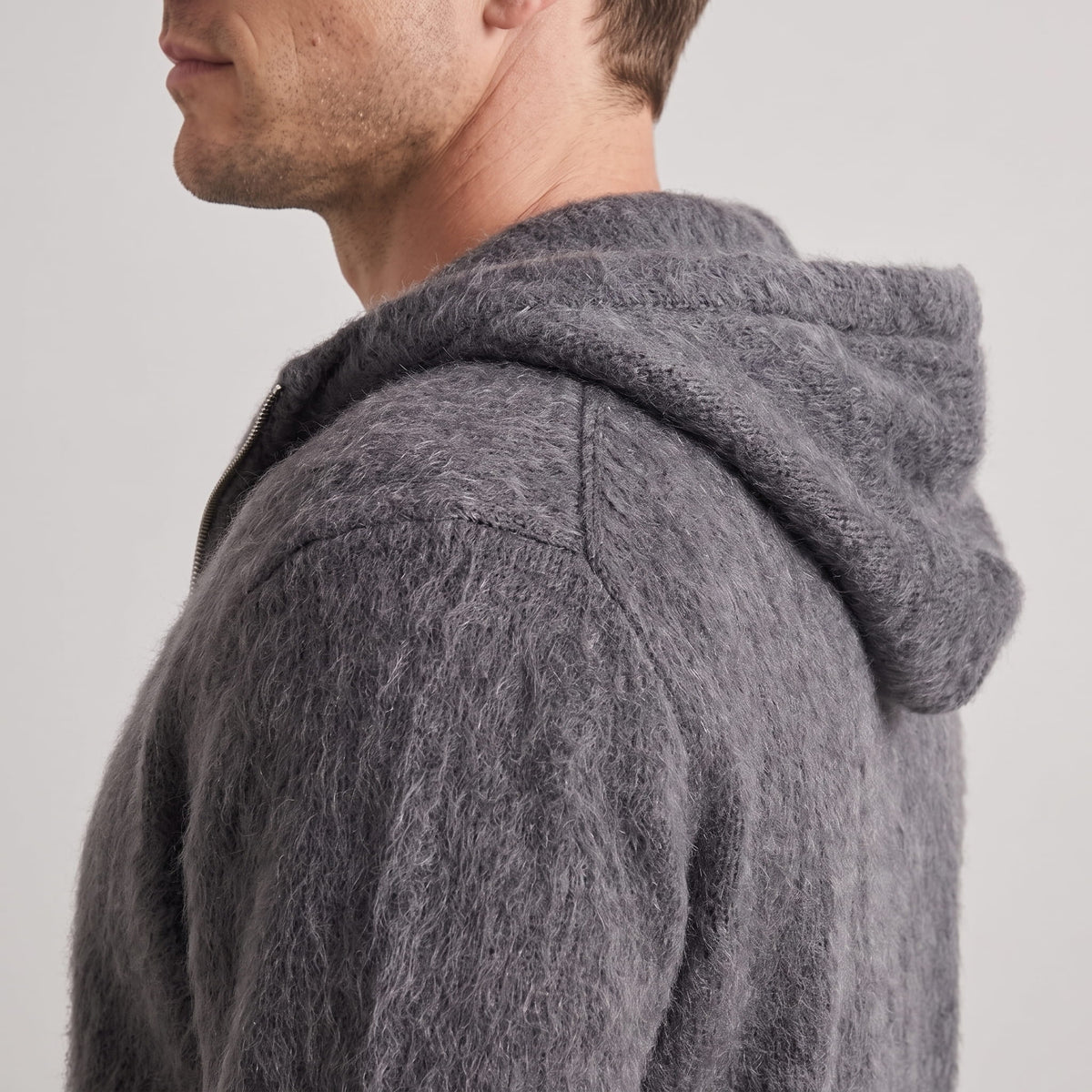 Side view of the gray cardigan's knit hood and dropped shoulder seam