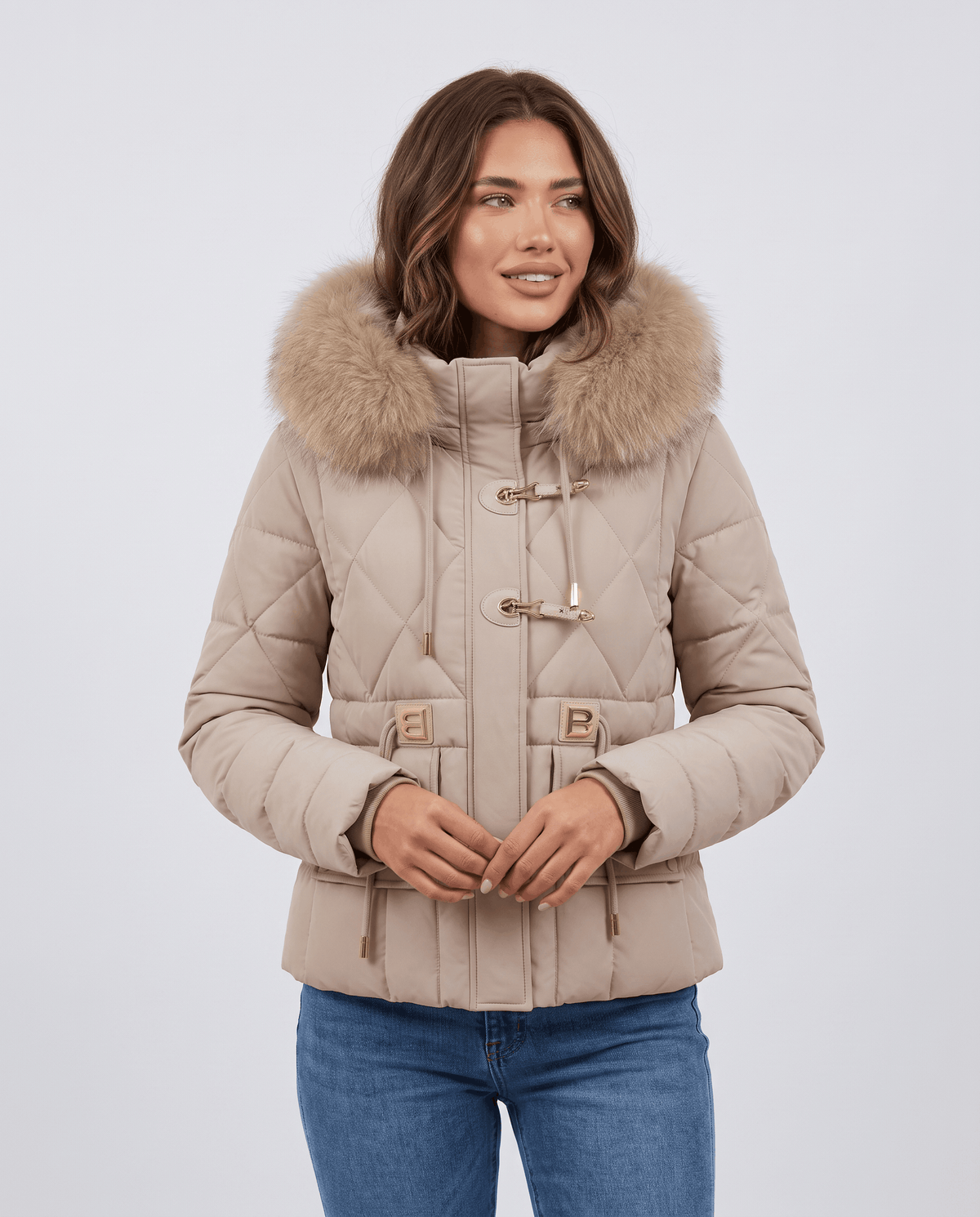 Model in beige quilted jacket with plush-trim hood and jeans, front view