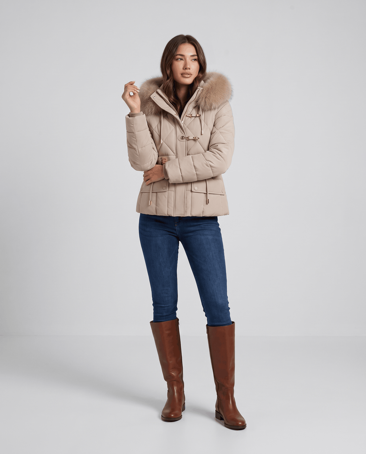 Full-length view of model in beige quilted jacket, jeans and brown boots