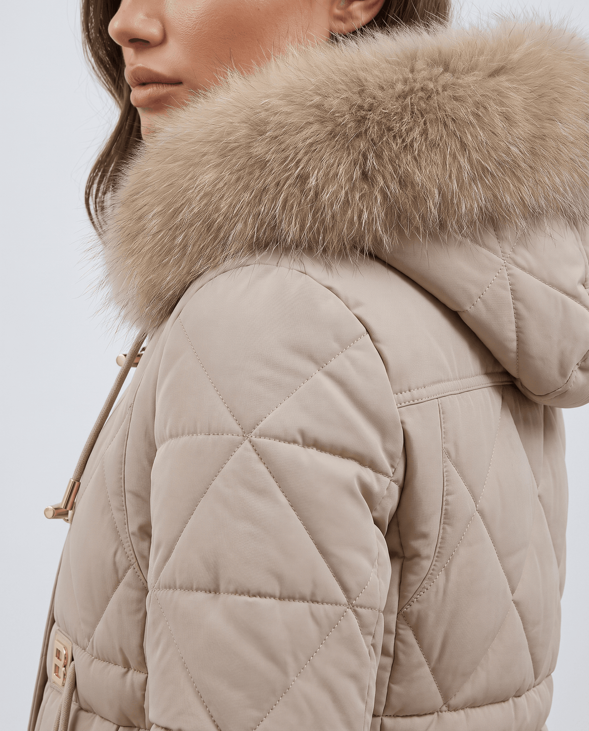 Close-up of beige plush hood trim and diamond quilted sleeve