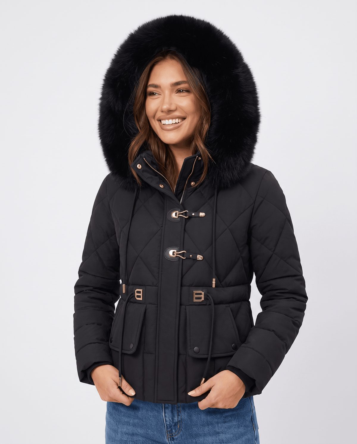 Model in black quilted jacket with large plush-trim hood up, front view